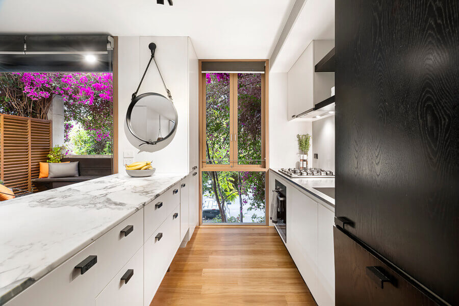 Kitchen with refaced cream cabinet doors and a dark worktop