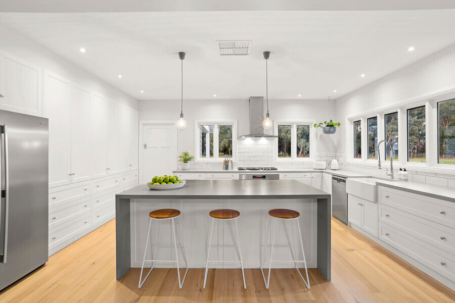 Finished modern white kitchen with an island and bar seating